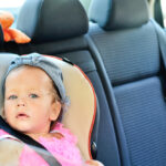 Peuter meisje in zitje op de achterbank van een auto